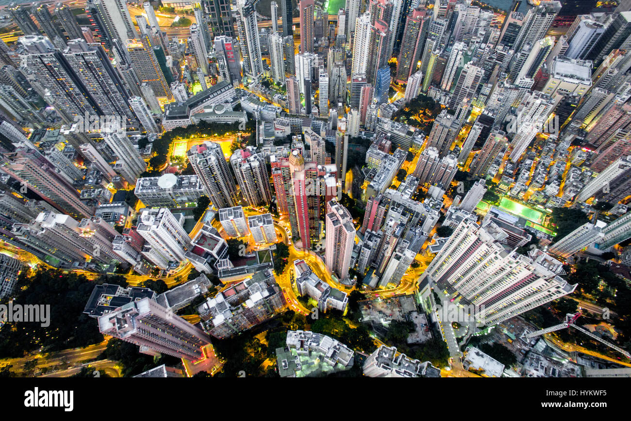 HONG KONG, CHINA: AERIAL shots taken by a drone from one thousand six hundred and forty feet in the air show the incredible clusters of skyscrapers in what is one of the world’s most dense cities. Pictures reveal a distinct lack of green space among the high concentration of multi-coloured tower blocks looking like concrete spikes darting out from the surface at varying heights. Closer inspection reveals roof gardens and connecting road networks weaving throughout the giant structures.  Other pictures show the China, DJI Phantom 3 Professional drone used to capture these airborne images. Photo Stock Photo