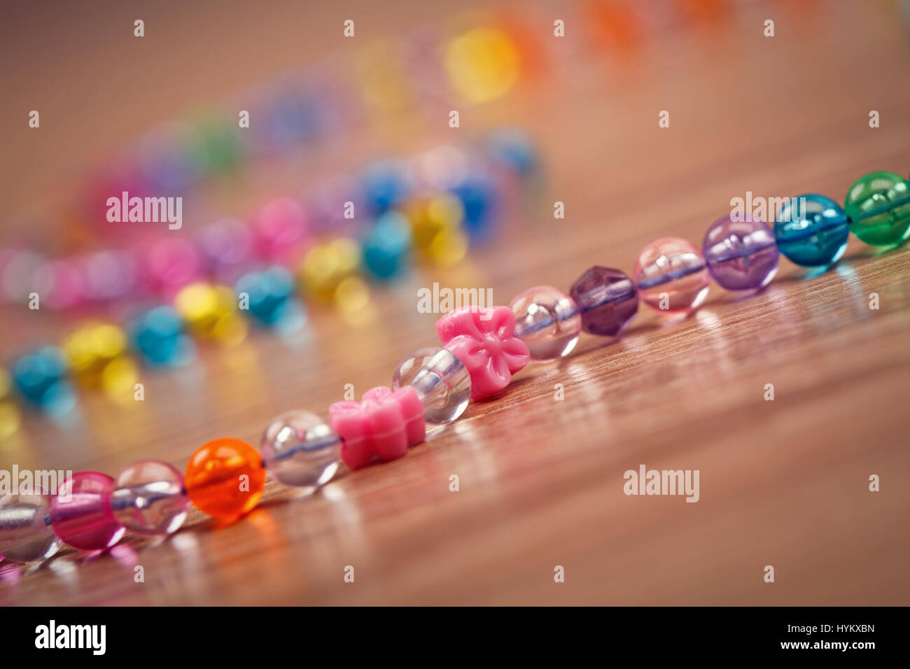 snake of colored beads on a wooden background Stock Photo