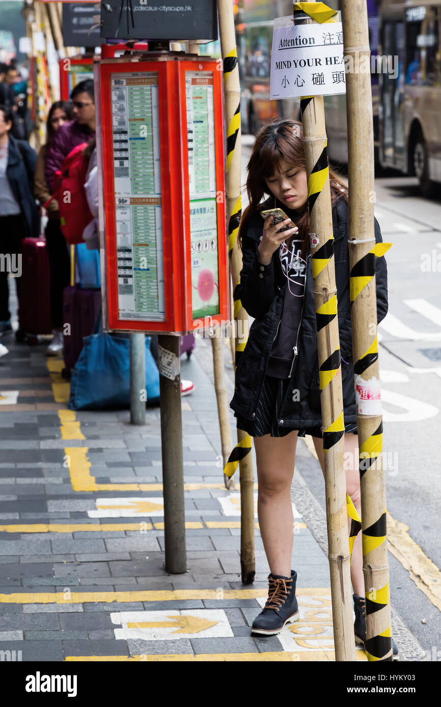 Hong Kong, Hong Kong - March 10, 2017: street scene with unidentified woman in Tsim Sha Tsu, that i is a major tourist hub in Hong Kong, with many hig Stock Photo