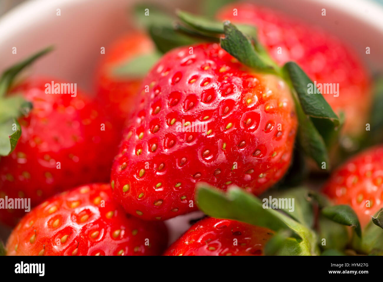 Bowl with fresh strawberry on blue wooden table Stock Photo - Alamy