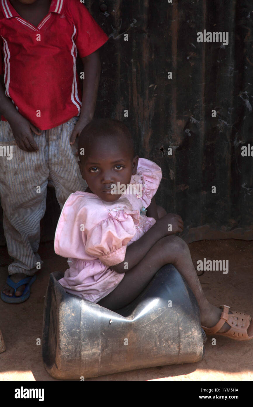 A child sitting on a plastic container in Kibera slums, Nairobi, Kenya, East Africa Stock Photo