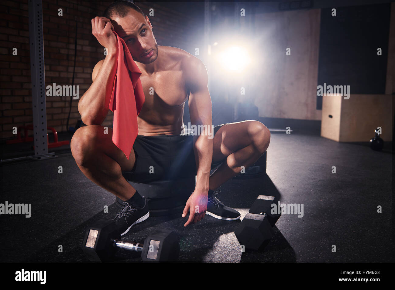 Young bodybuilder wiping sweat with towel Stock Photo