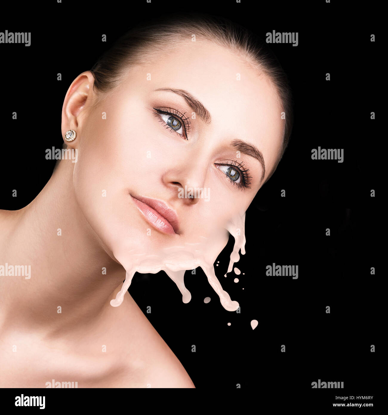 Young woman with beige foundation splashes. Stock Photo