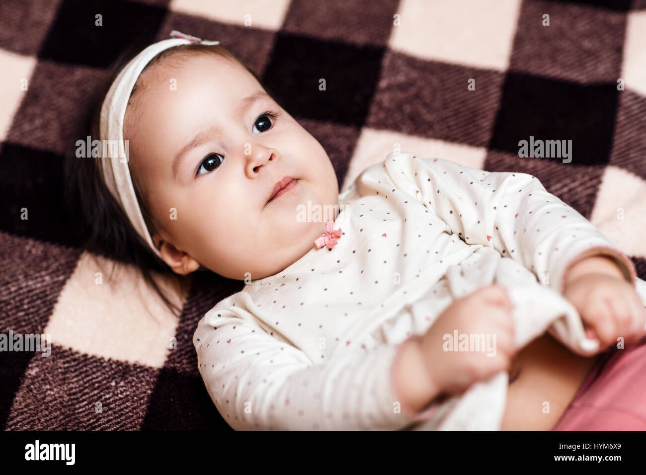 Baby girl lying on the checkered plaid Stock Photo
