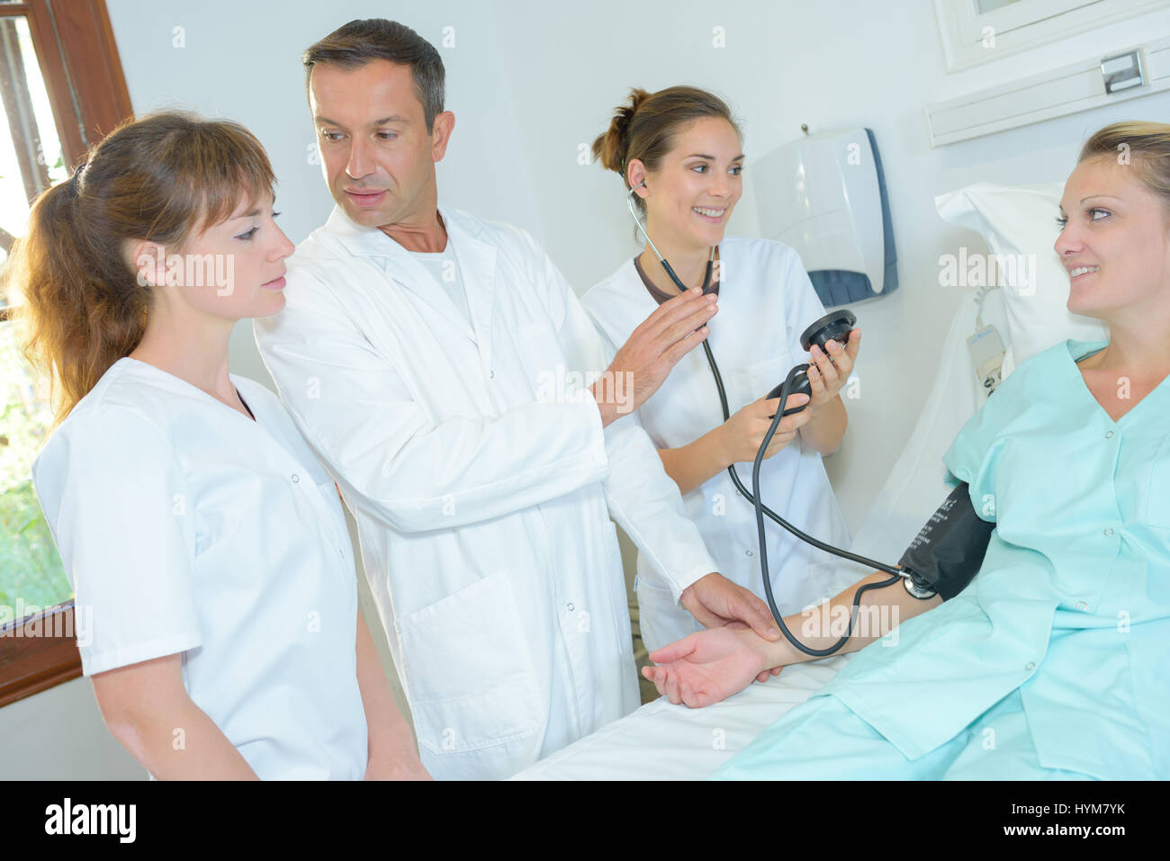 Doctor demonstrating how to take blood pressure Stock Photo