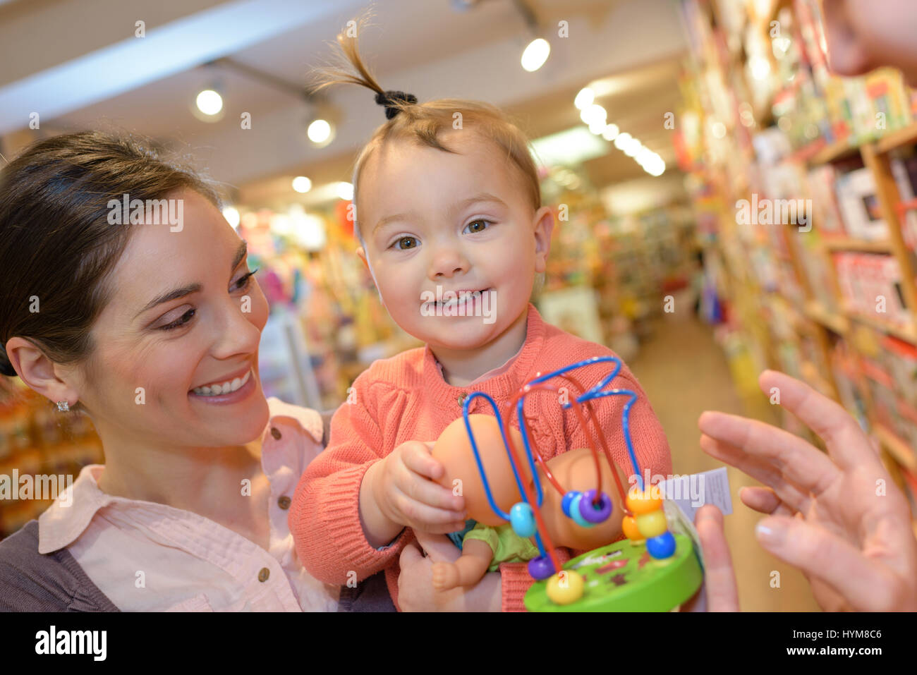mother and daughter in cart in toy store Stock Photo Alamy