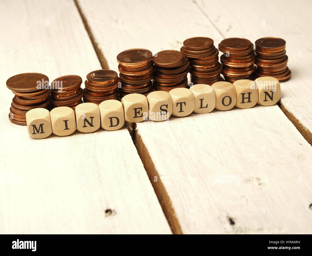 Mindestlohn Konzept mit Holzwürfeln und Kleingeld als Geldstapel Stock Photo