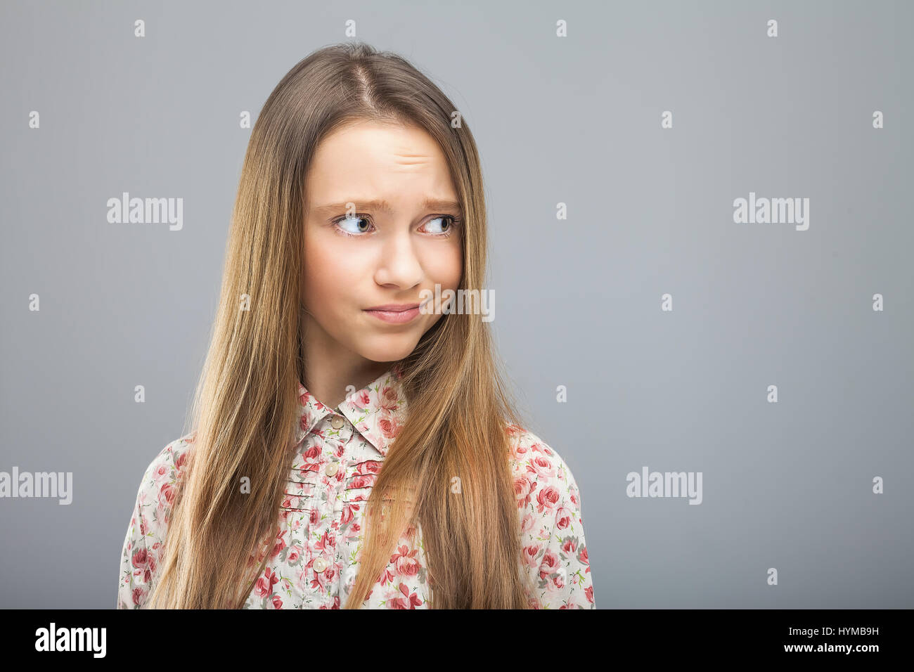 young blond pretty girl in hipster shirt looking disregard at something. Concept of disrespect, negation, rejection, reluctance, unwillingness Stock Photo
