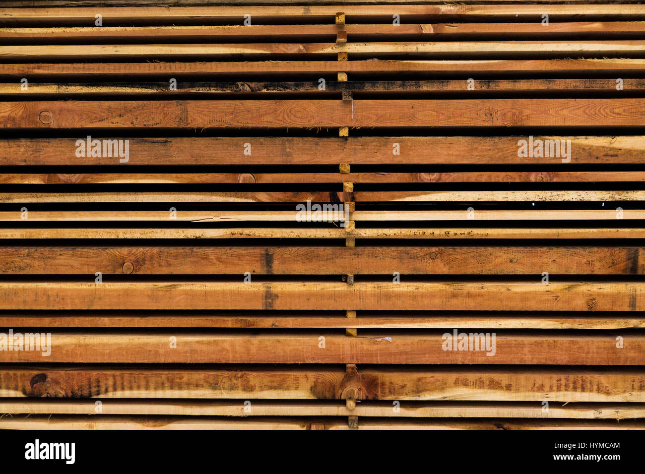 Different size sawn wooden planks stacked in pile and stored for use as building material Stock Photo