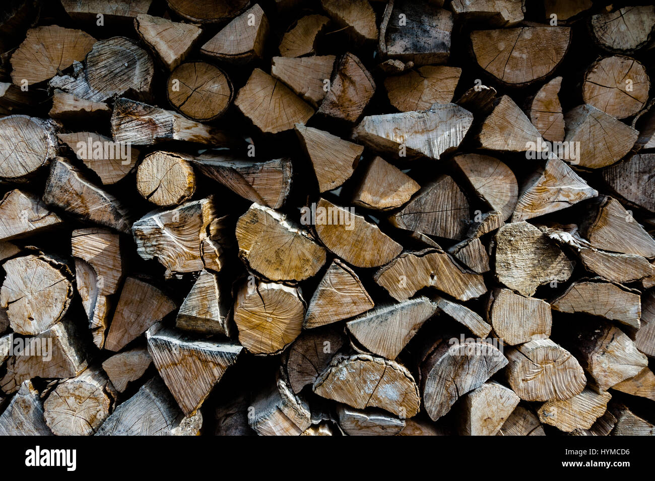 Firewood cut and stacked neatly in pile outside ready for use in