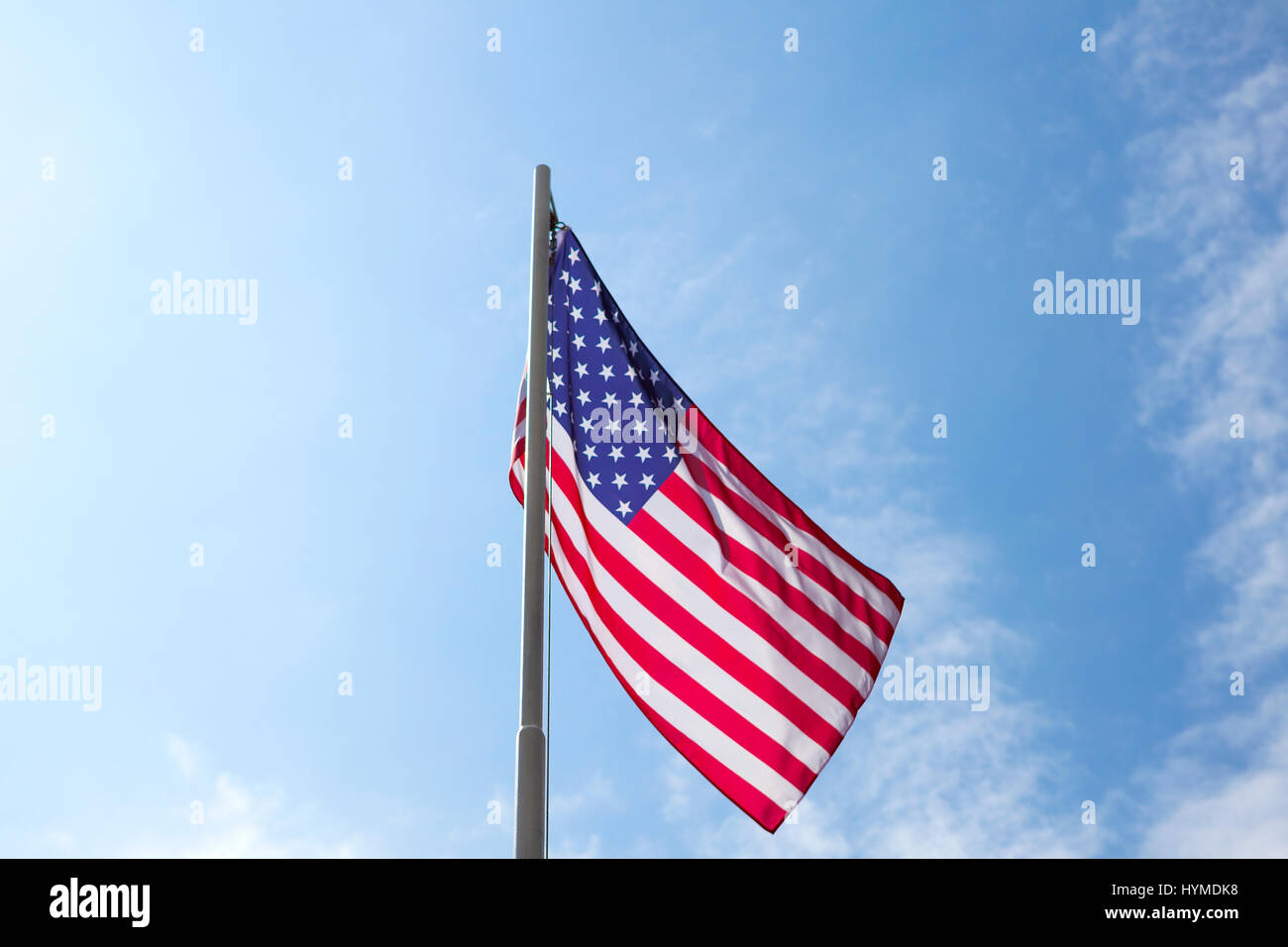Flag of United States on a flagpole in front of blue sky Stock Photo ...