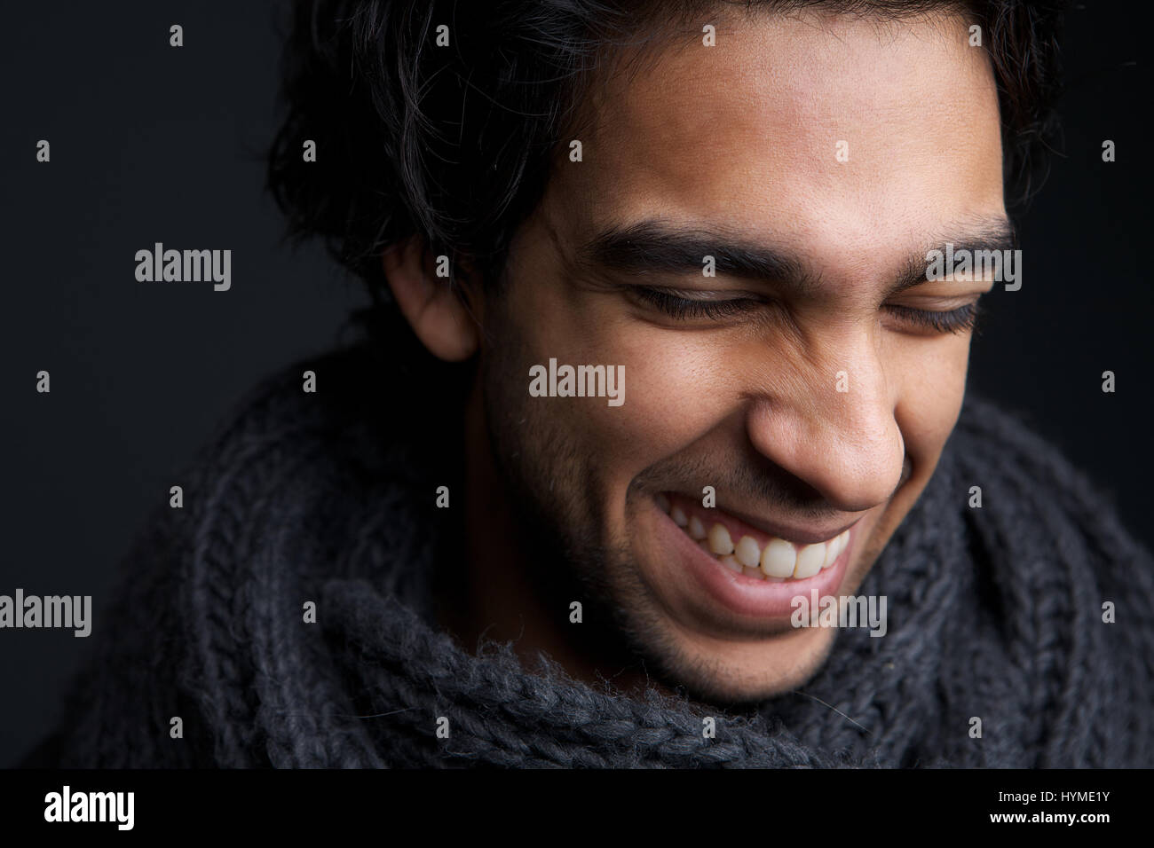 Close up portrait of a young man laughing with gray scarf Stock Photo