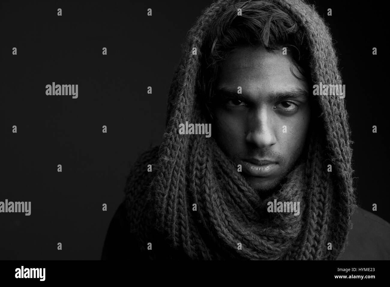 Black and white portrait of a young man with wool scarf covering head Stock Photo