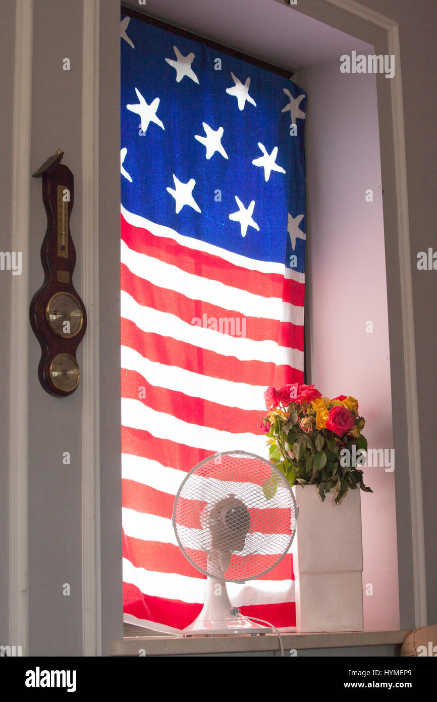 Patriotic American flag-like window decoration with  a vase of wilting flowers and a fan. Zawady Central Poland Europe Stock Photo