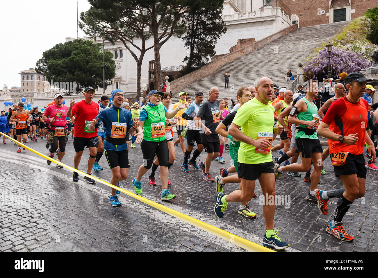 Rome, Italy - April 2, 2017: Athletes participating at the 23rd Rome marathon run through the street circuit passing the Capitol, seat of the Municipa Stock Photo