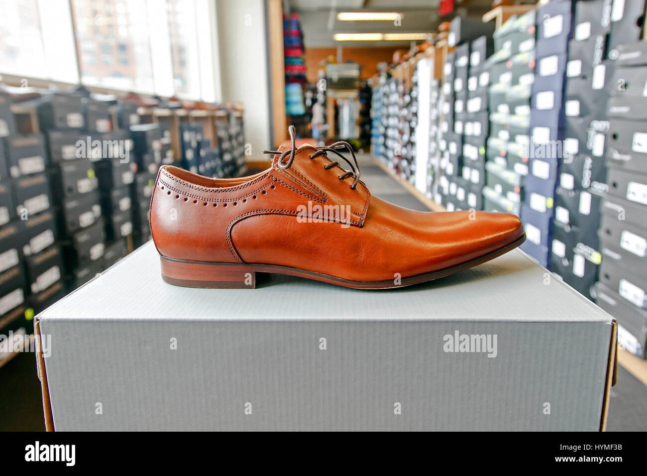 Mens dress shoe in a shoe store with stacks of boxes in the background. Stock Photo