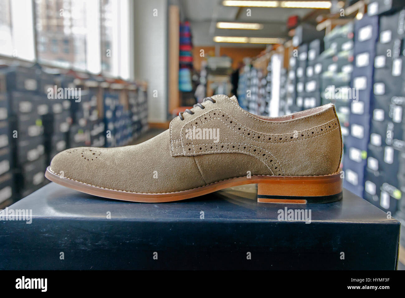 Mens dress shoe in a shoe store with stacks of boxes in the background. Stock Photo