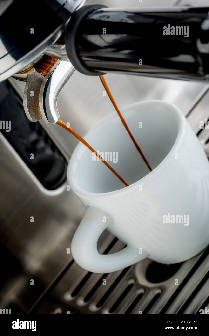 Traditional pump espresso coffee machine pouring shot into white cup