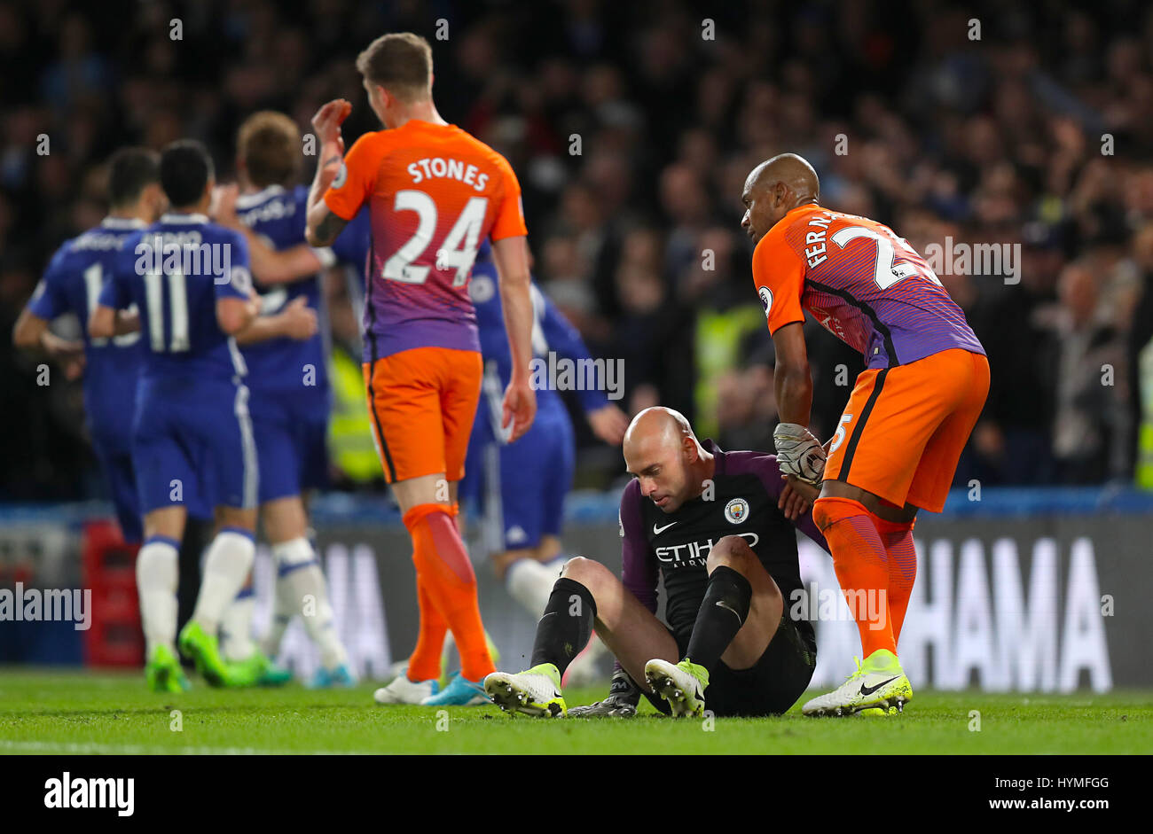Manchester City goalkeeper Willy Caballero is helped up by Manchester City's Fernandinho after he concedes a penalty during the Premier League match at Stamford Bridge, London. Stock Photo