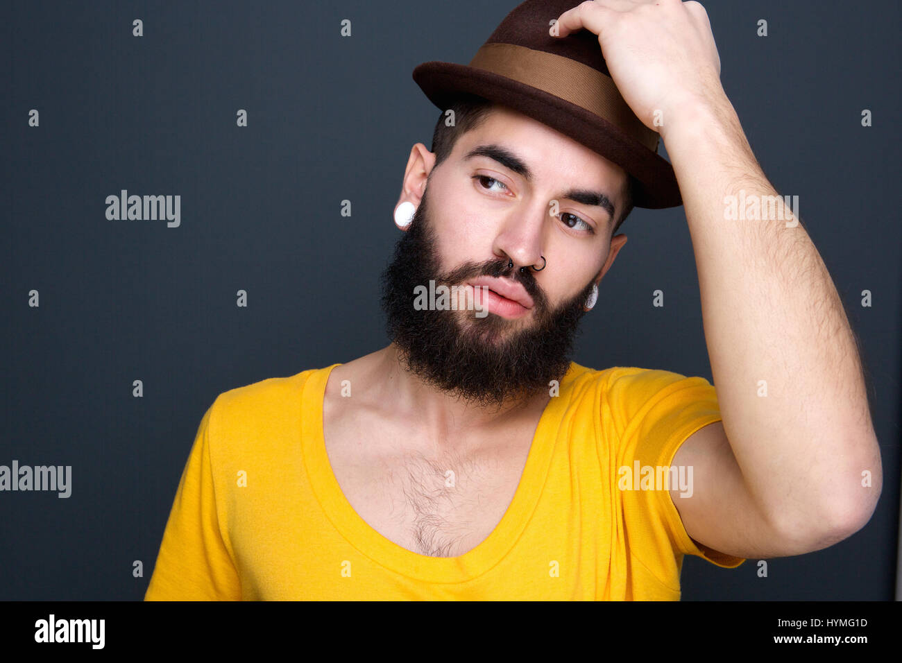 Close up portrait of a young modern guy holding hat on head Stock Photo ...