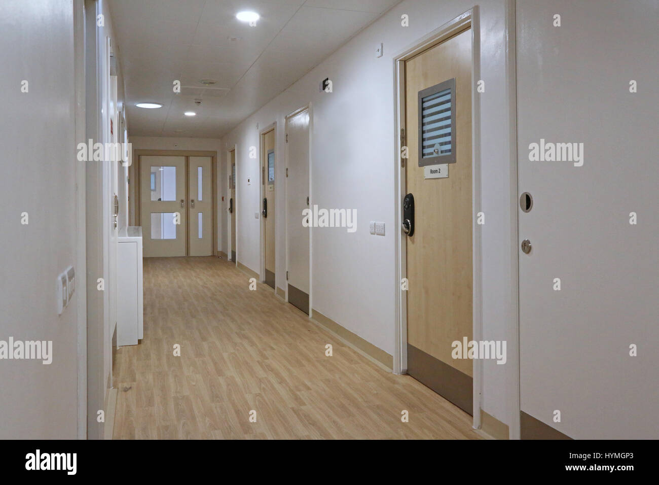 Corridor in a new secure, residential psychiatric unit. Shows bedroom doors featuring anti-ligature door handles and lock fitting. Stock Photo