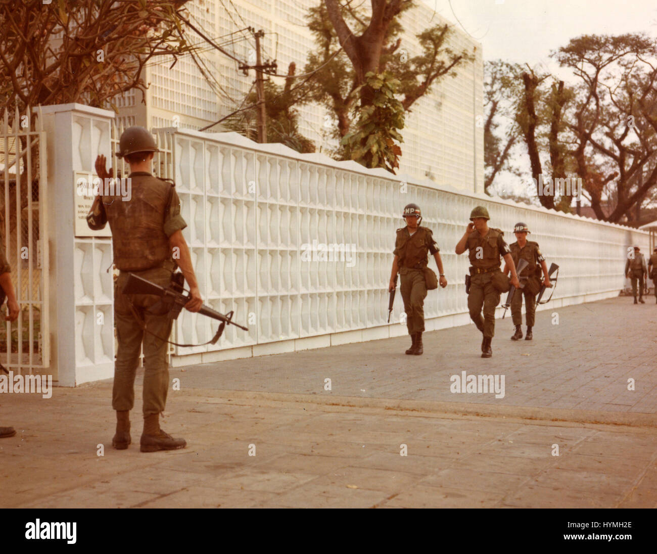 A group of 19 Viet Cong gained entrance to the American Embassy in Saigon by blowing a hole in the northeast corner of the wall. MPs guard the entrance to the embassy after the attack. 31st January 1968. Stock Photo