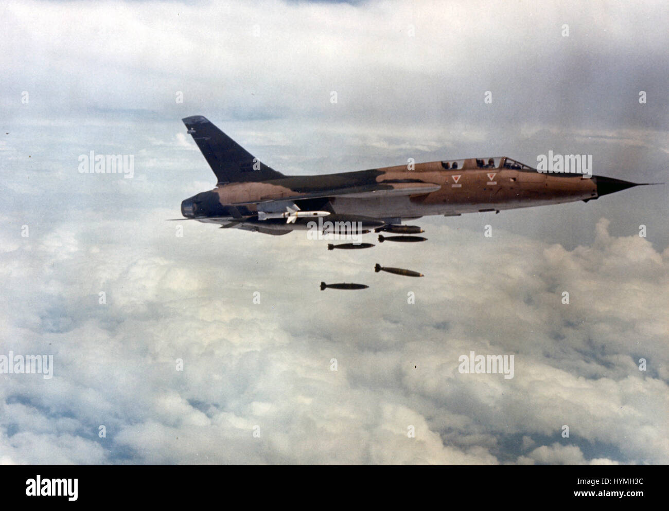 A US Air Force F-105F Thunderchief armed with AGM-45 Shrike missiles bombs a surface-to-air missile (SAM) site in North Vietnam. 1967. Stock Photo