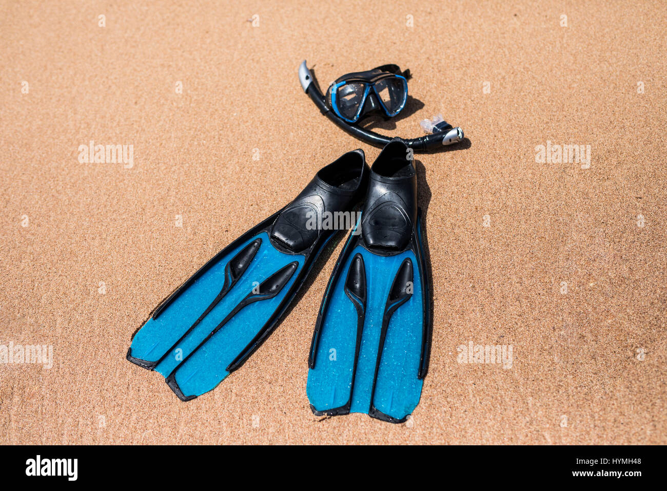 Beach vacation fun snorkel equipment on sand with ocean waves splashing water. Scuba diving and