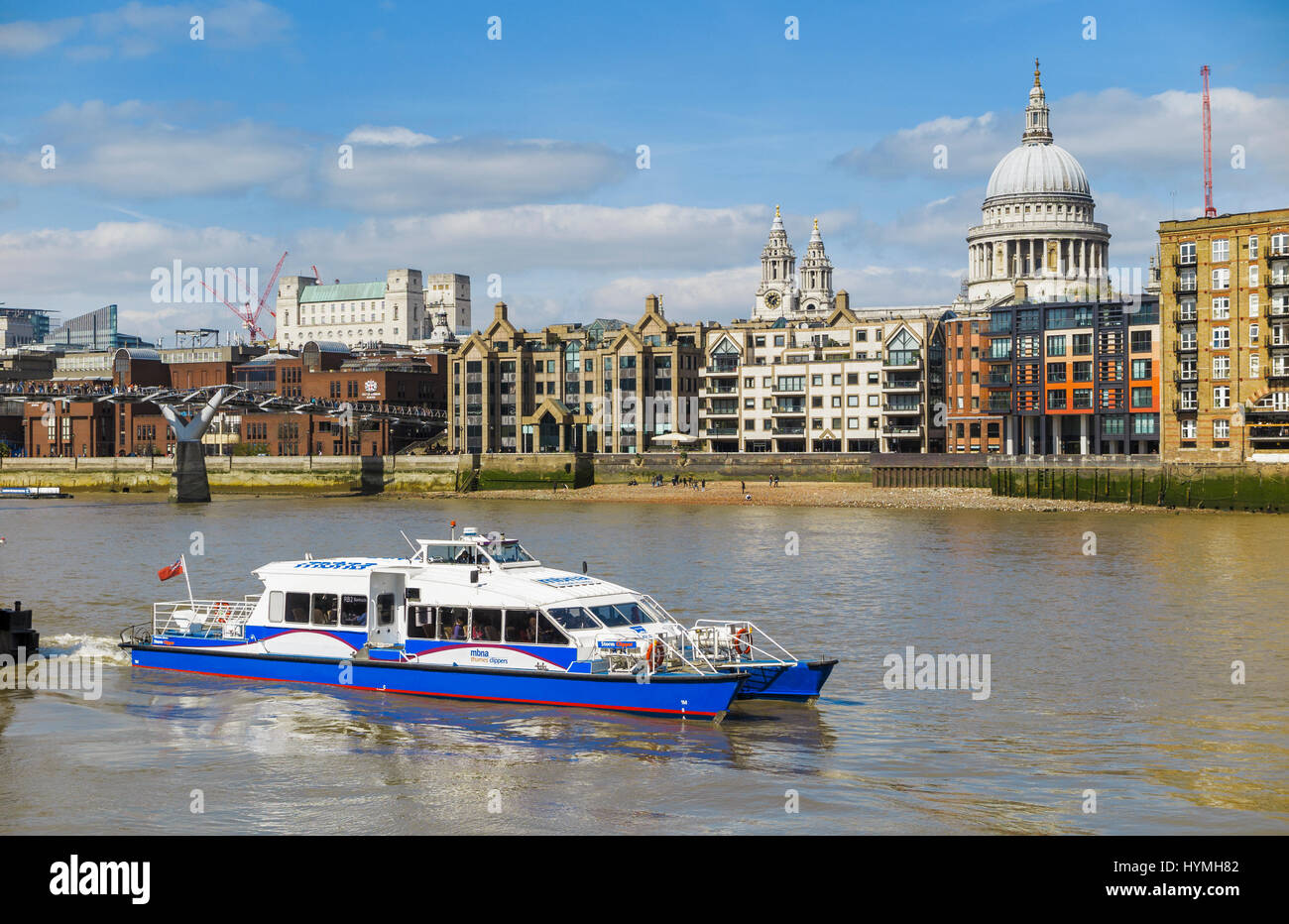 Blue and white Catamaran Thames Clipper boat, part of the river bus service, Bankside Pier, St Paul's Cathedral in the background, on a fine sunny day Stock Photo