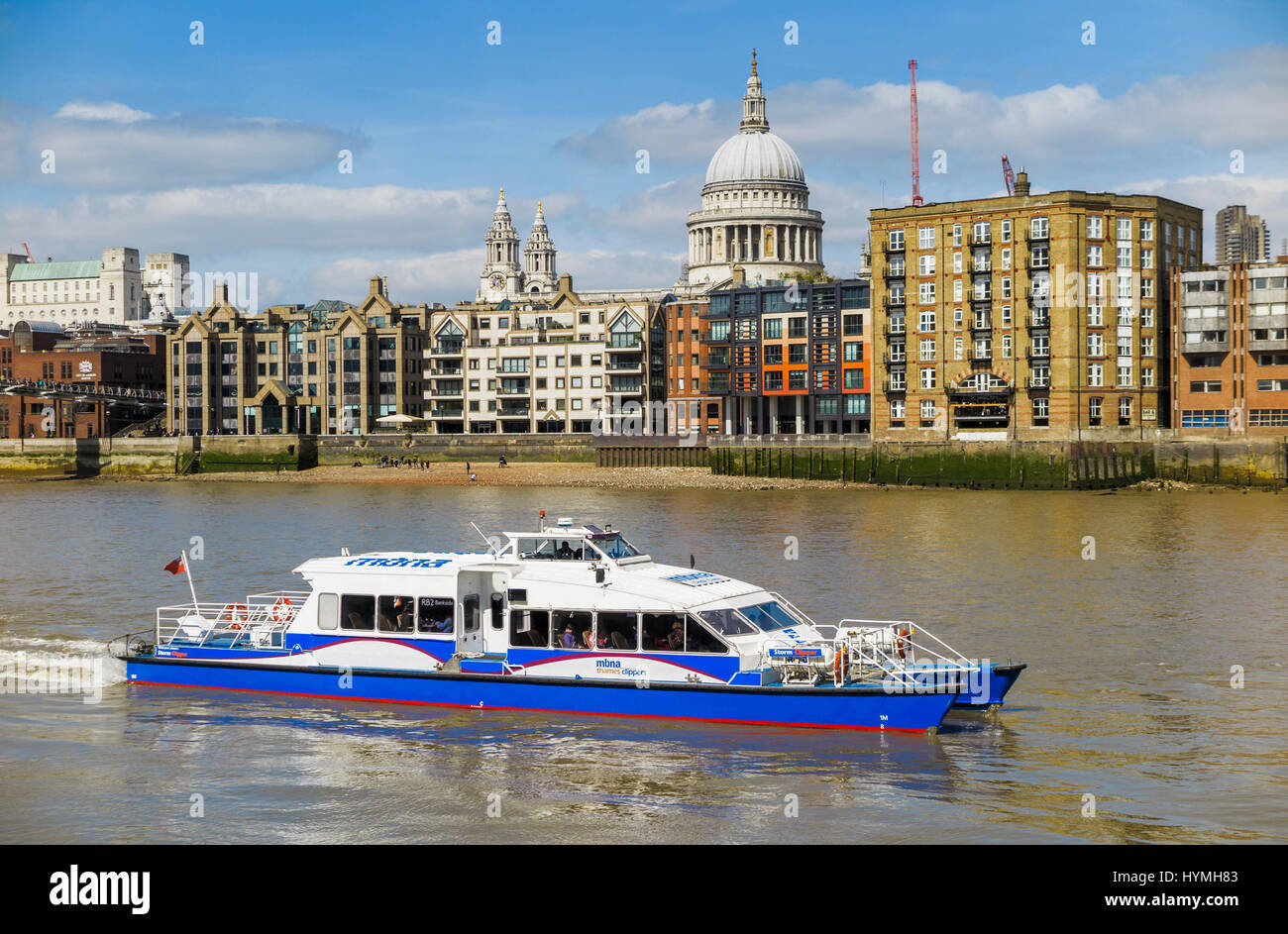 Blue and white Catamaran Thames Clipper boat forming part of the river bus service, Bankside pier, St Paul's in the background Stock Photo