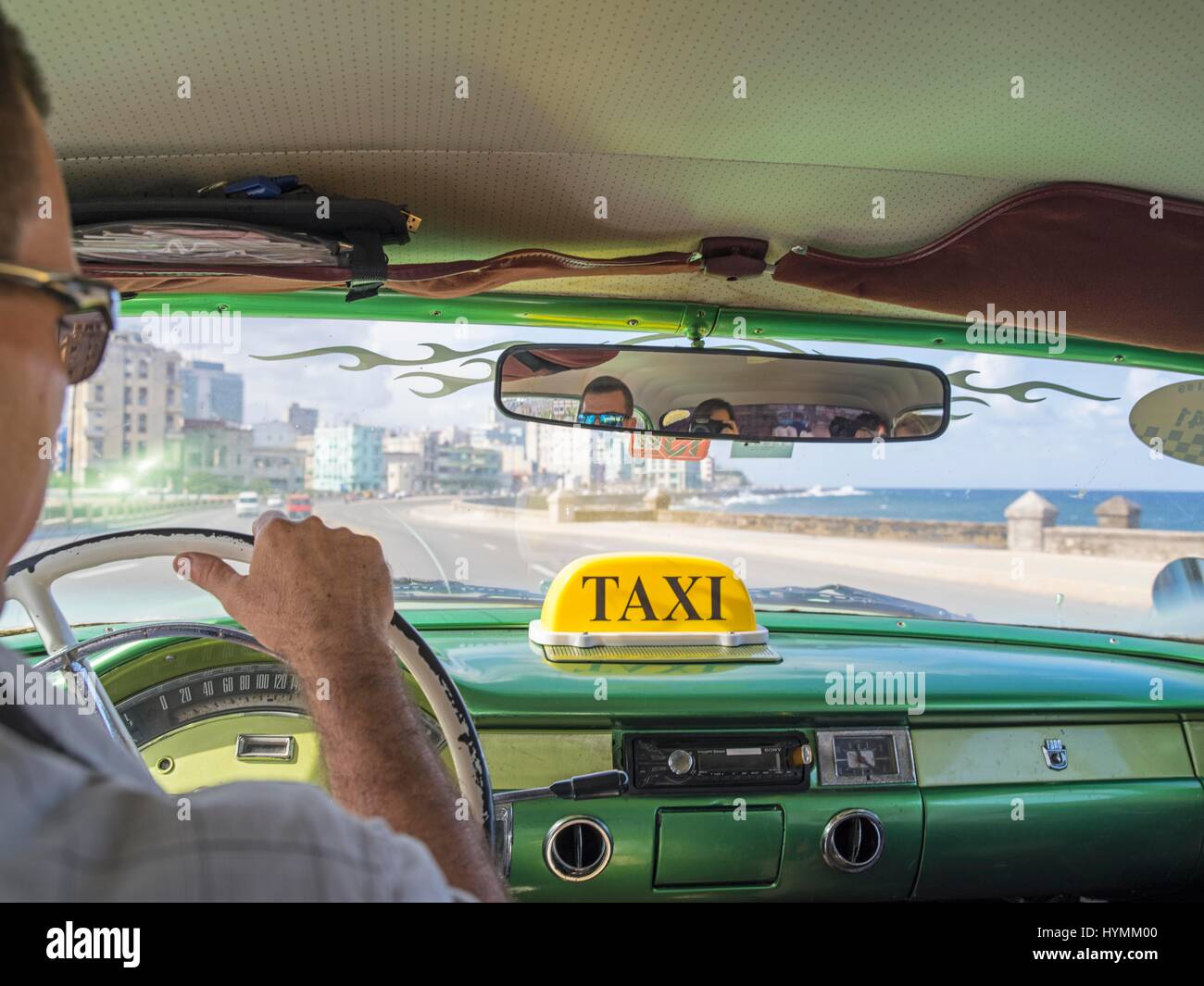 Close up picture of Cuban Taxi driver driving through the Malecon in Havana, Cuba Stock Photo