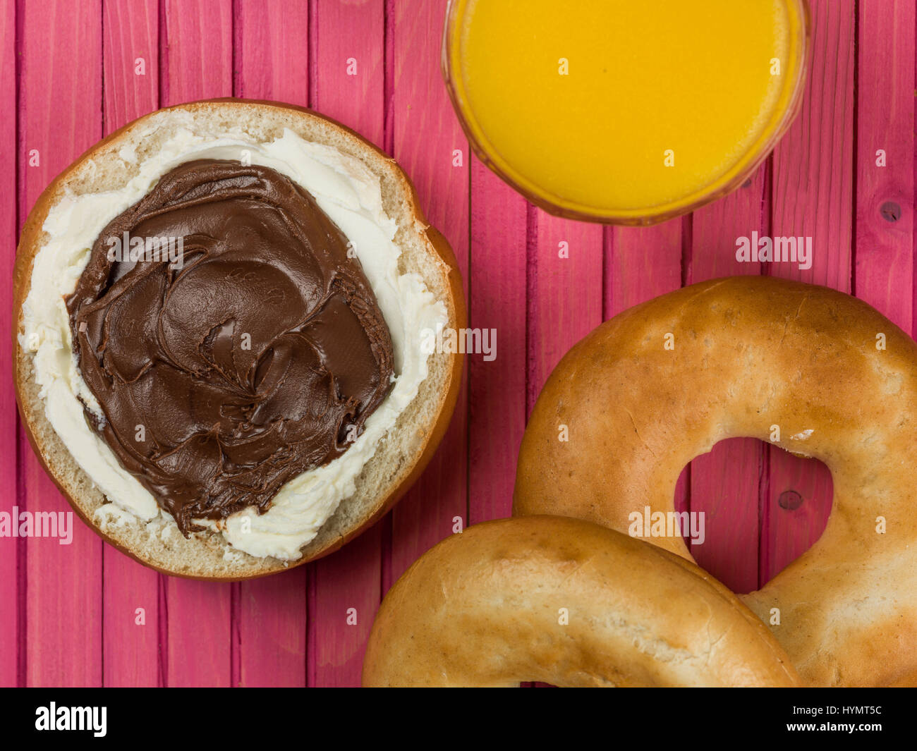 Chocolate Spread and Cream Cheese Bagel Against a Pink Background Stock Photo