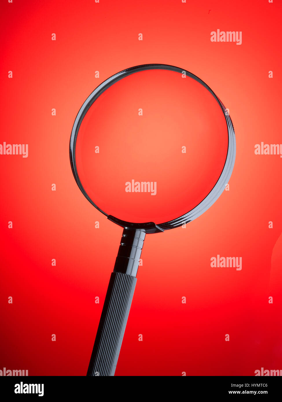 Magnifying Glass with red background Stock Photo