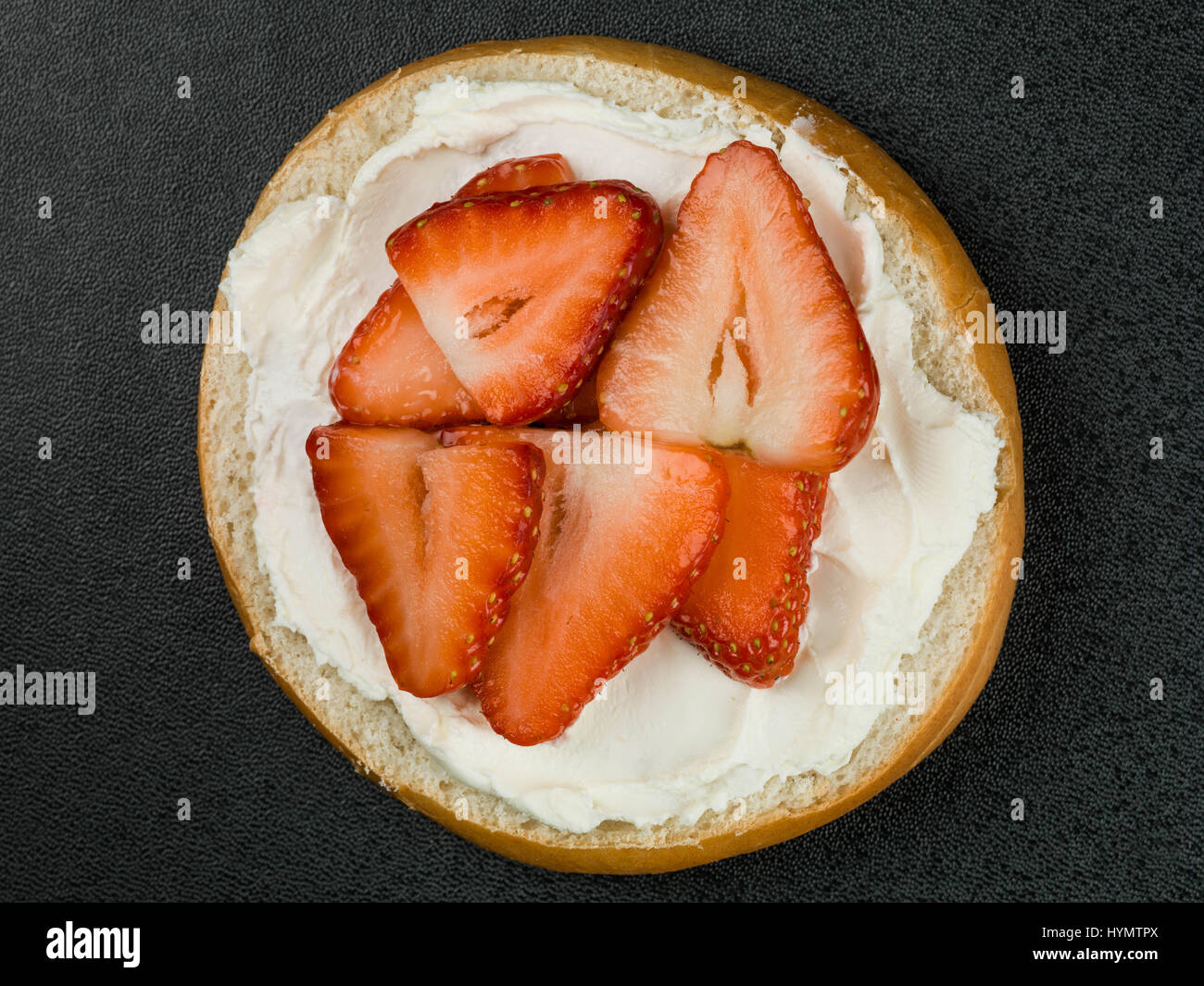 Banana and blueberry bagel with cream cheese on a pastel pink background  Stock Photo