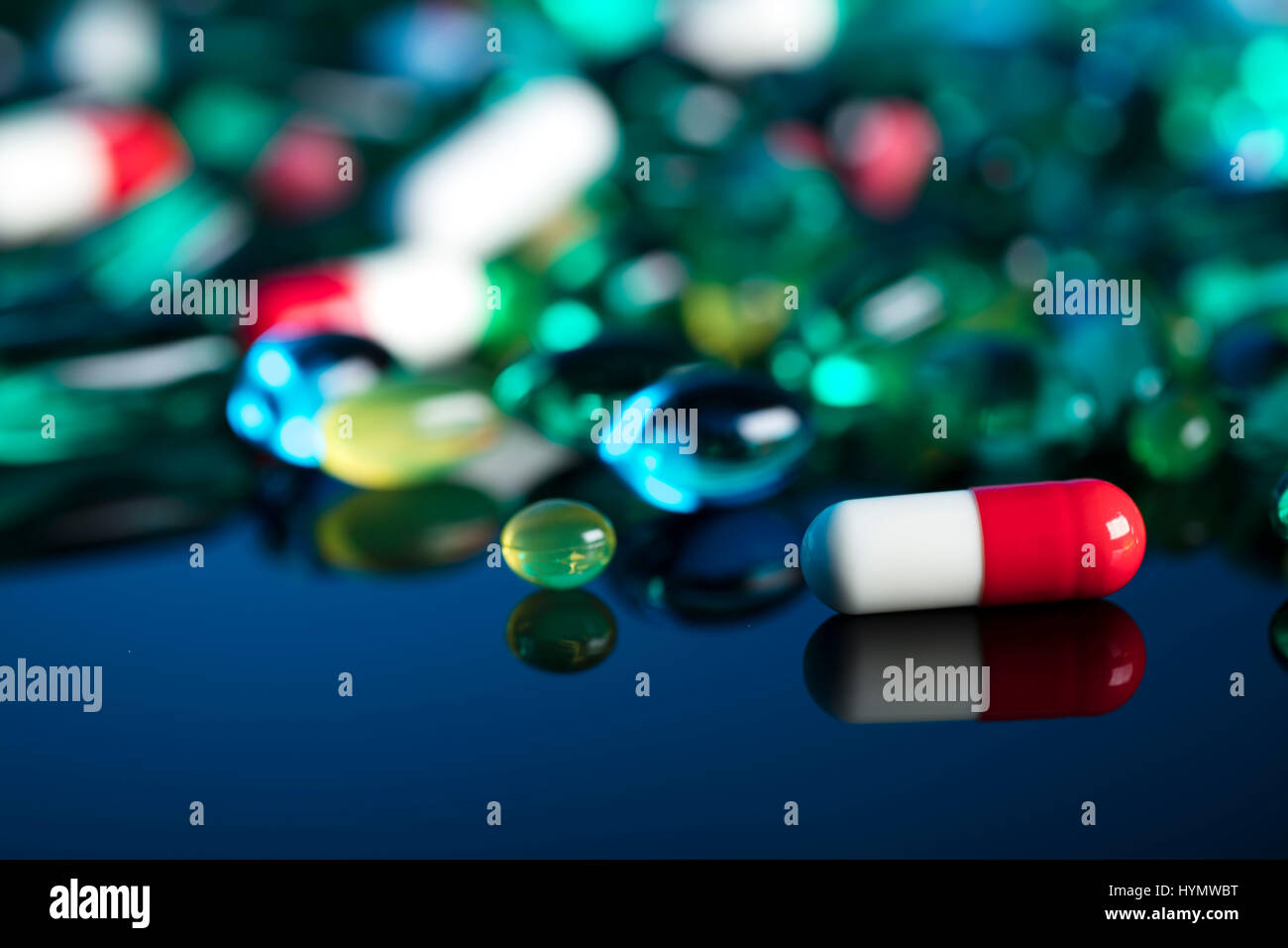 Pharmacy theme.  Set of different colorful pills on glass table. Background concept. Stock Photo