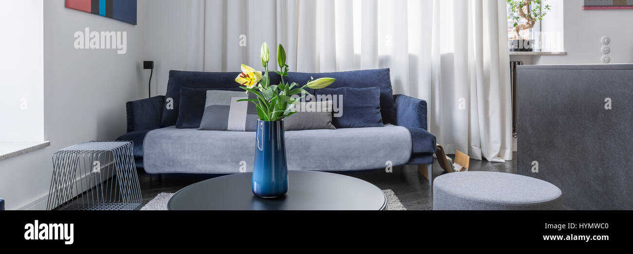 Flowers in vase on coffee table in stylish living room, panorama Stock ...