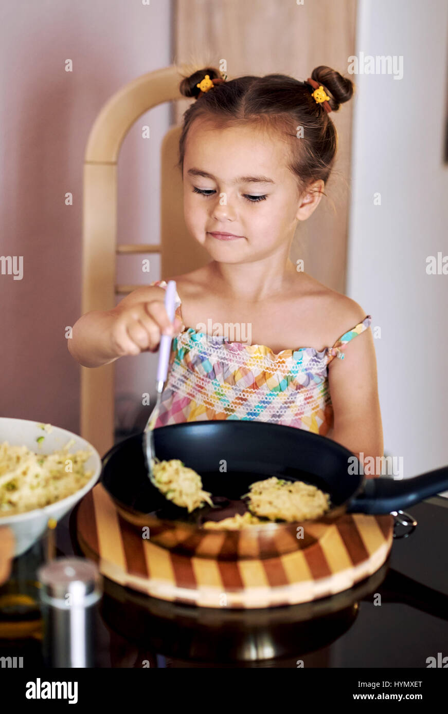 Cute little girl cooking potato pancakes at home Stock Photo Alamy