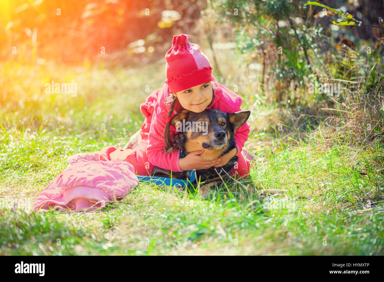 Happy little girl playing with dog in the forest Stock Photo - Alamy