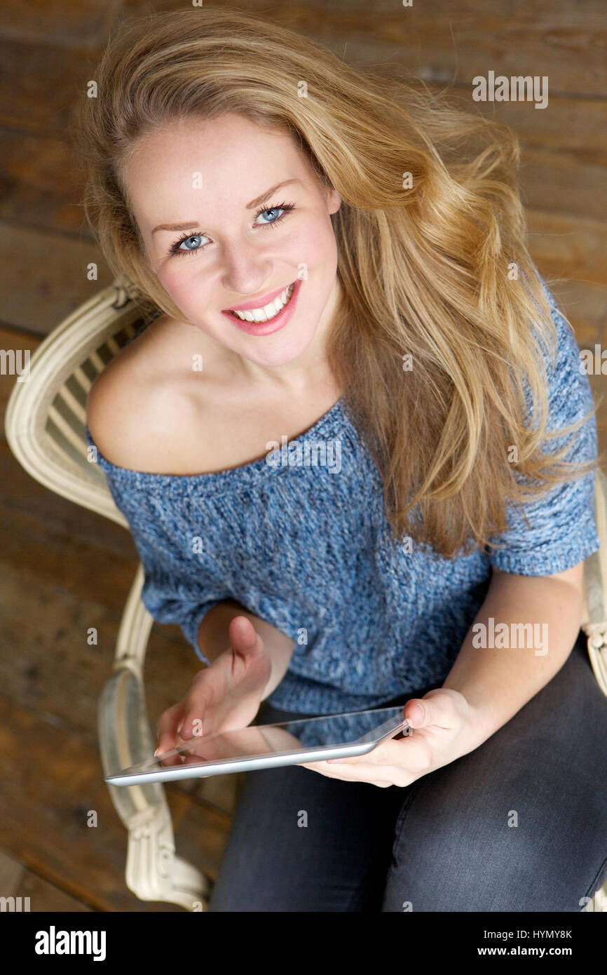 Portrait of a smiling woman relaxing with computer tablet Stock Photo