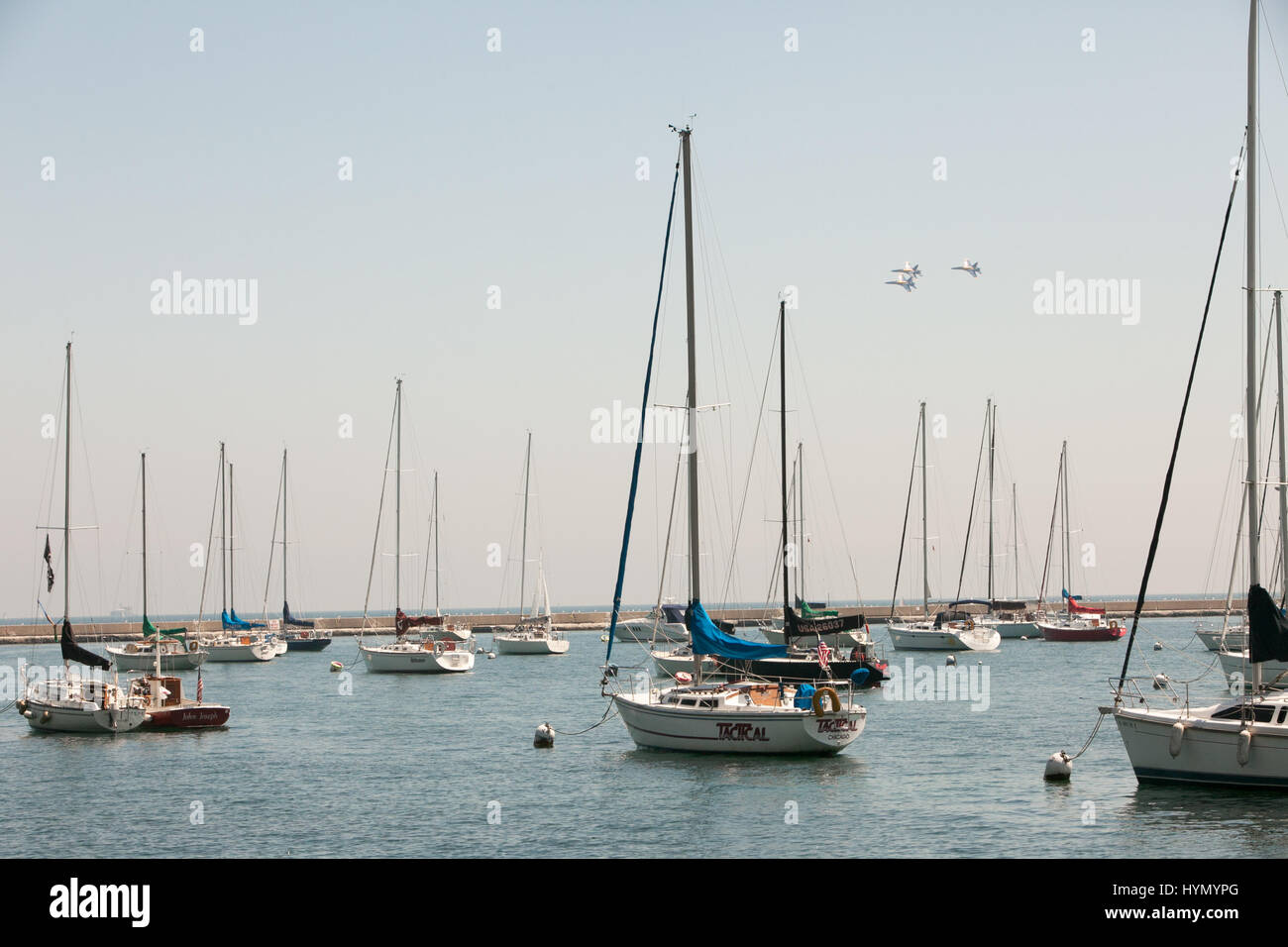 The Blue Angels fly in formation above Lake Michigan and sailboats docked in Chicago Harbors. Stock Photo
