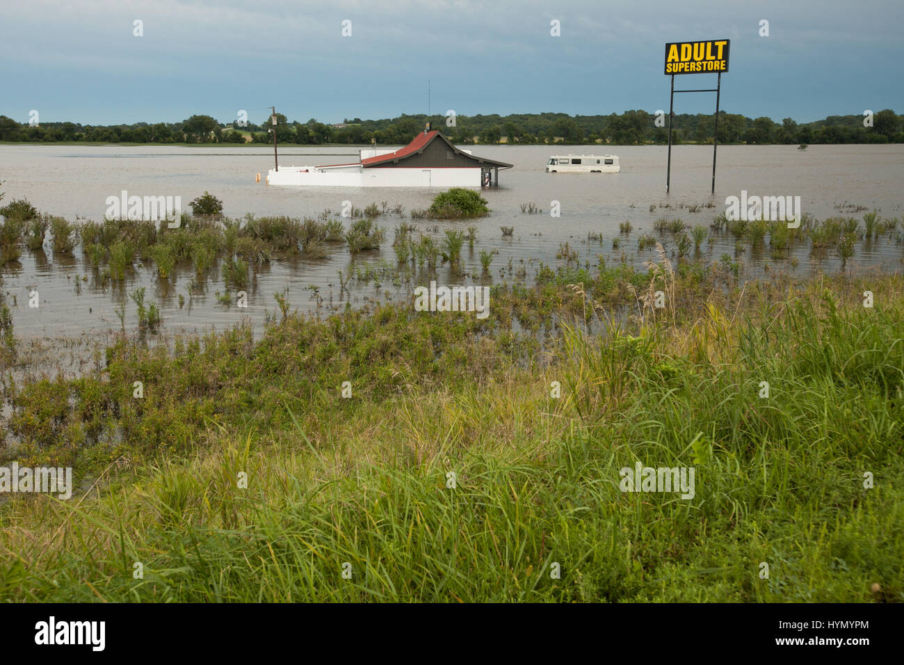 A recreational vehicle and an adult superstore are submerged in flood waters. Stock Photo