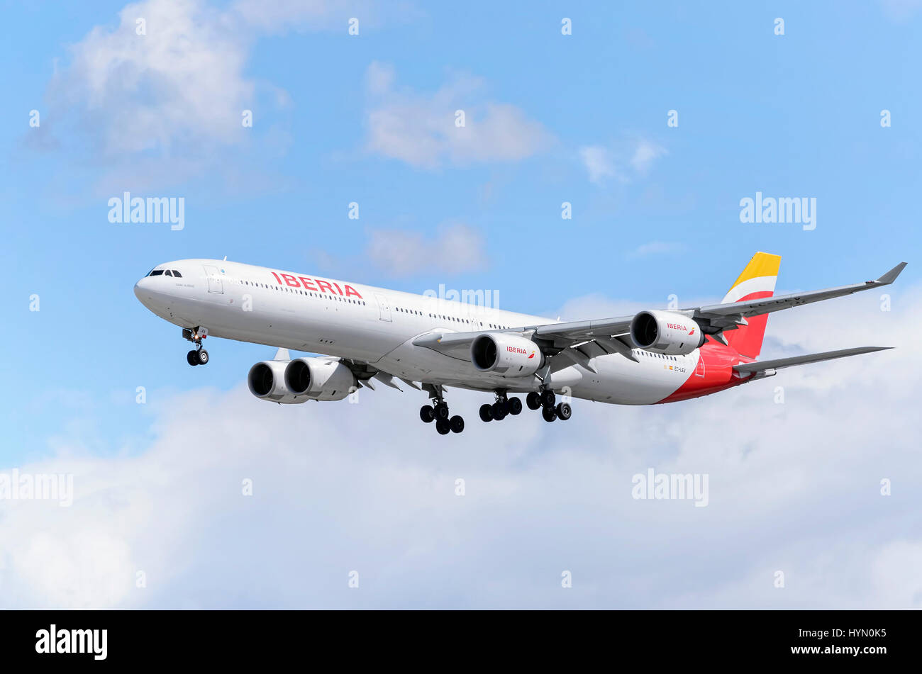 Plane Airbus A340, of spanish airline Iberia, is landing in Madrid - Barajas, Adolfo Suarez airport. Blue sky with clouds. Stock Photo
