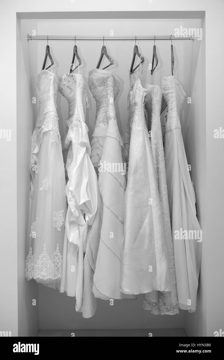 Collection of wedding dresses in the shop in black and white Stock