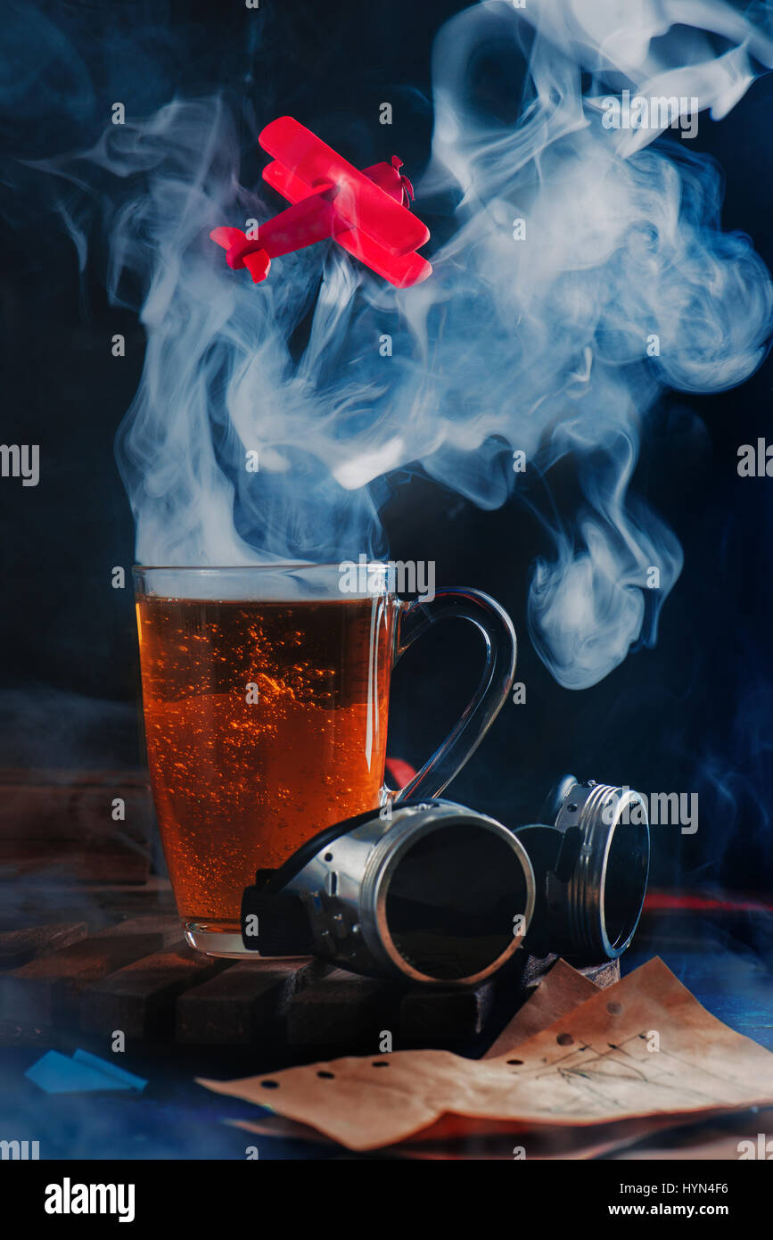 Cloud of steam rising from a coffee cup with a flying red airplane Stock Photo