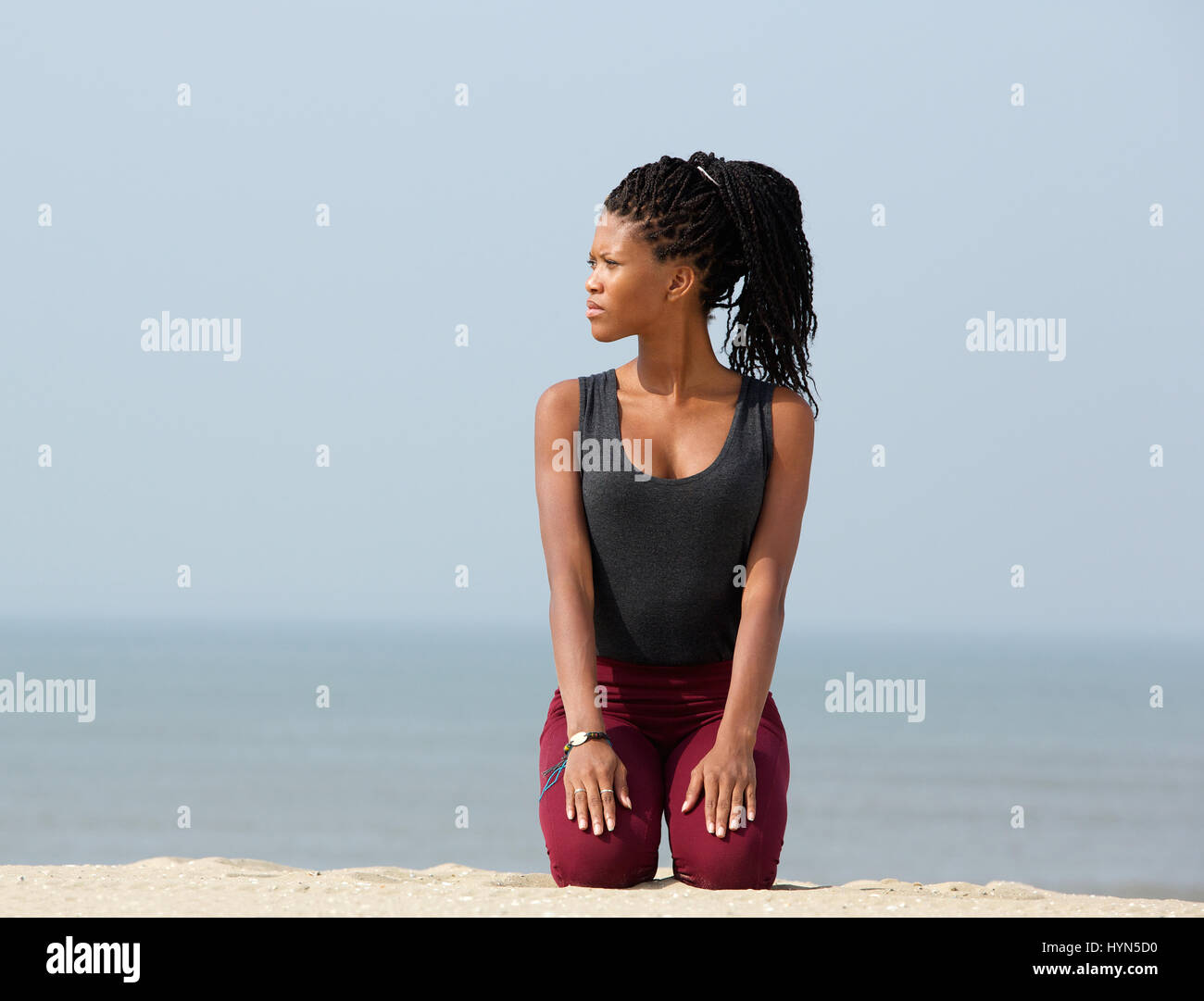 Woman kneeling on sand at a beach hi-res stock photography and images ...