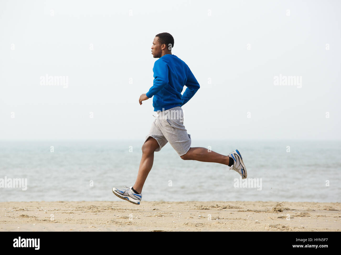 Healthy young black man jogging at the beach Stock Photo