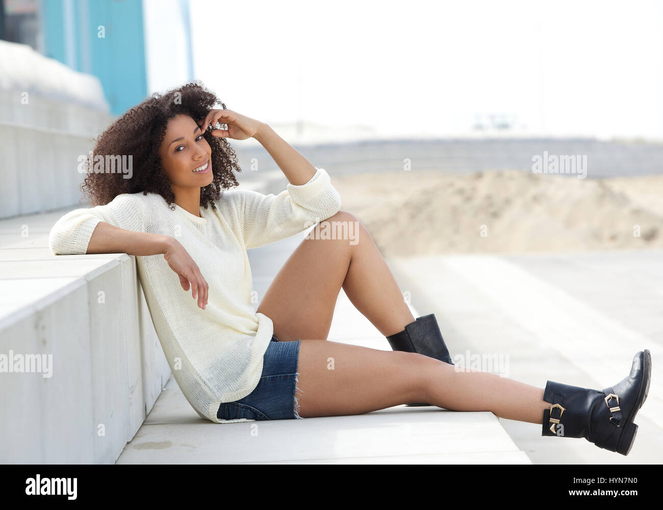 Portrait of a beautiful young african american woman sitting outdoors ...