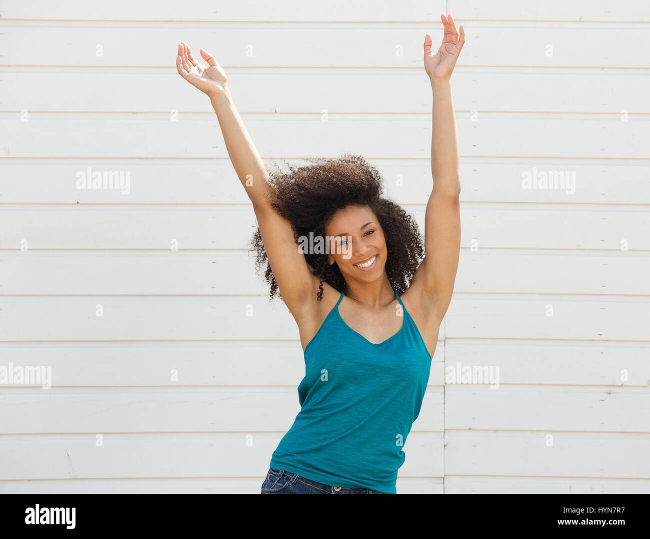 Portrait of a joyful young woman with arms up in the air Stock Photo ...