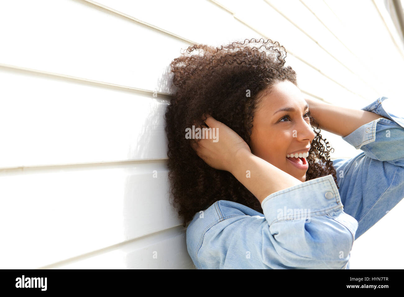 Close up portrait of a beautiful young woman with curly hair smiling ...
