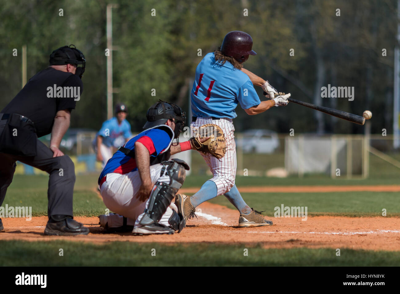 Baseball batter hits the ball, ball touching the baseball bat Stock